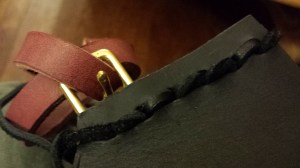 The adjustment buckle at the bottom of the quiver.