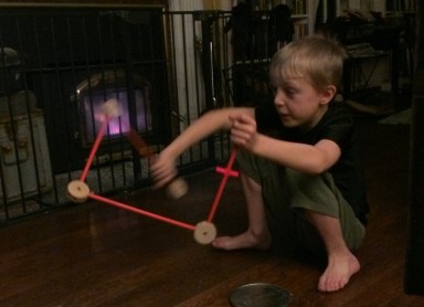 My son playing with Tinkertoys in front of thee fireplace.