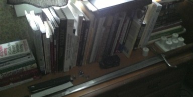 At the foot of the bed is my costuming, medieval history, and screenwriting row of books. And yes, that's a longsword. And it's sharp. I need to hang it up...